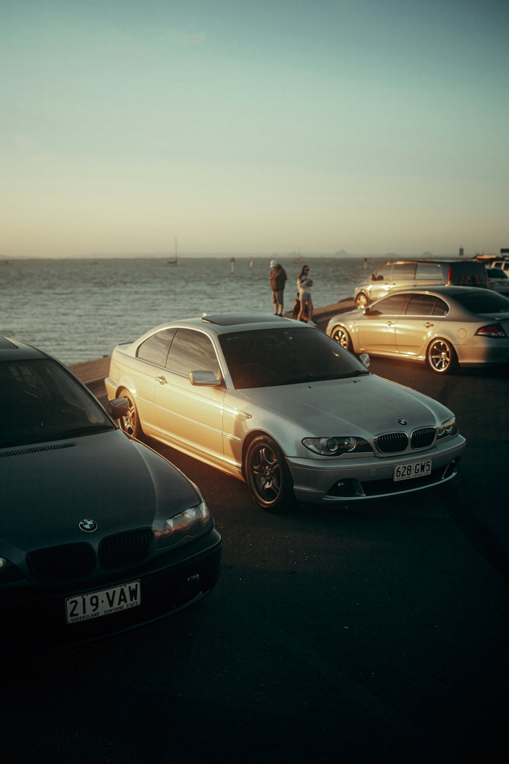 a group of cars parked next to each other near the ocean