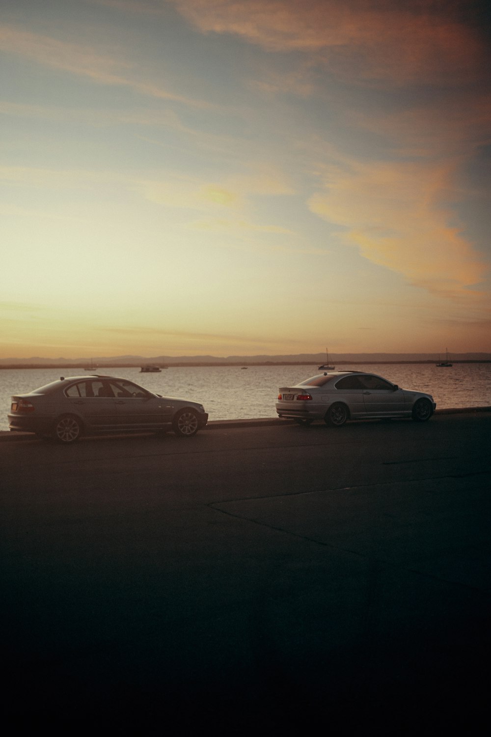 a couple of cars parked next to a body of water