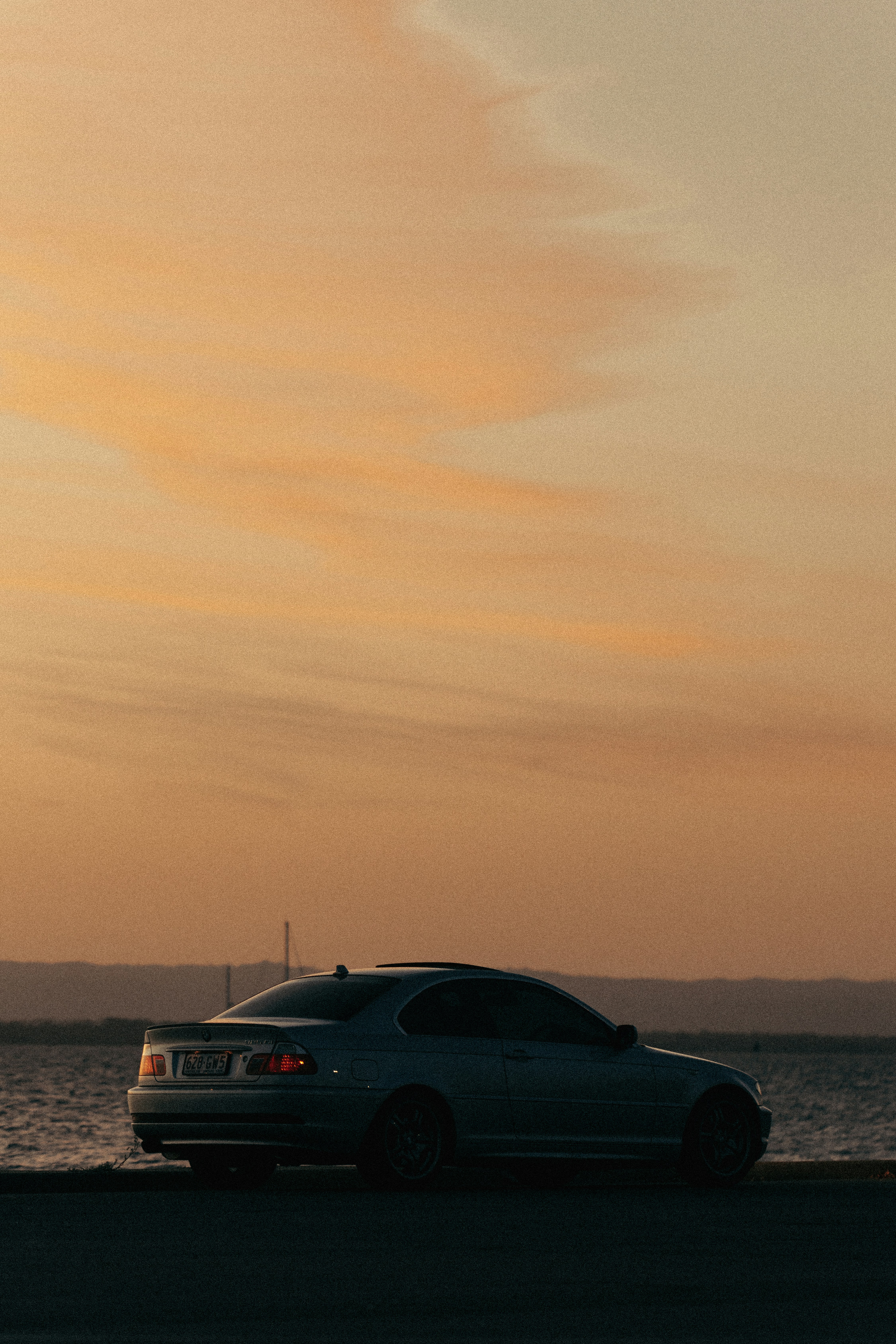 une voiture garée sur le bord de la route près de l’eau