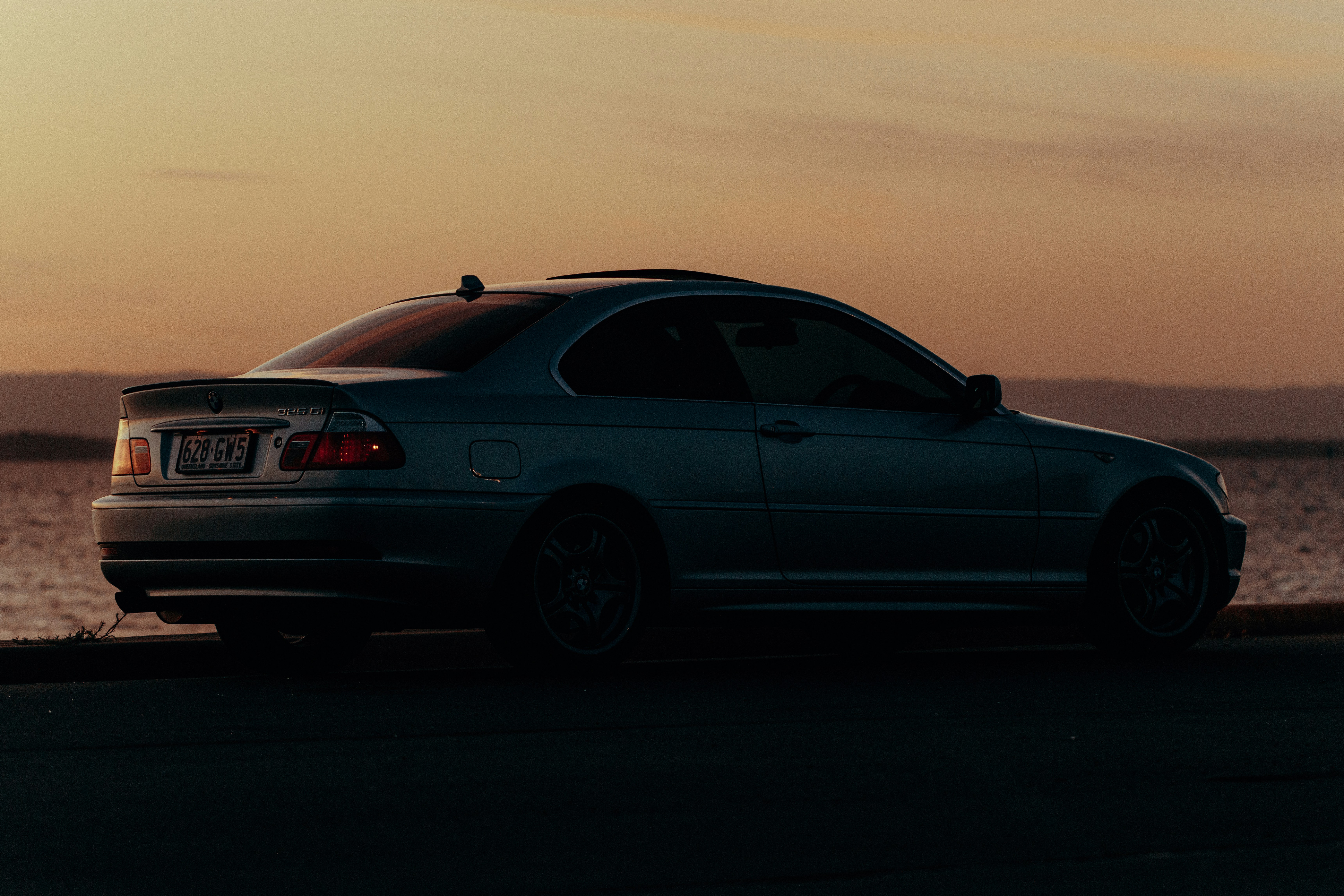une voiture garée sur le bord d’une route à côté d’un plan d’eau