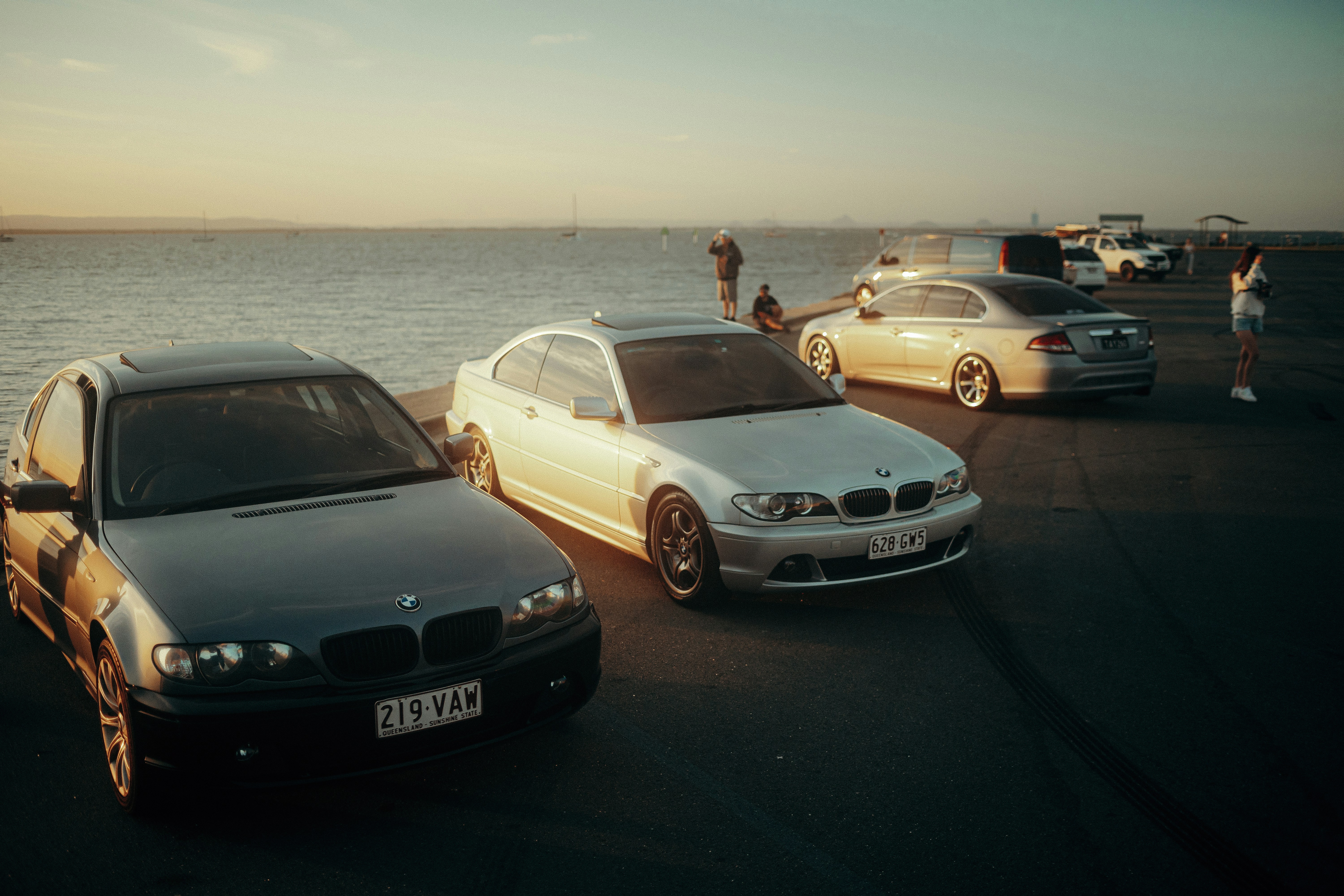 un groupe de voitures garées les unes à côté des autres près de l’océan