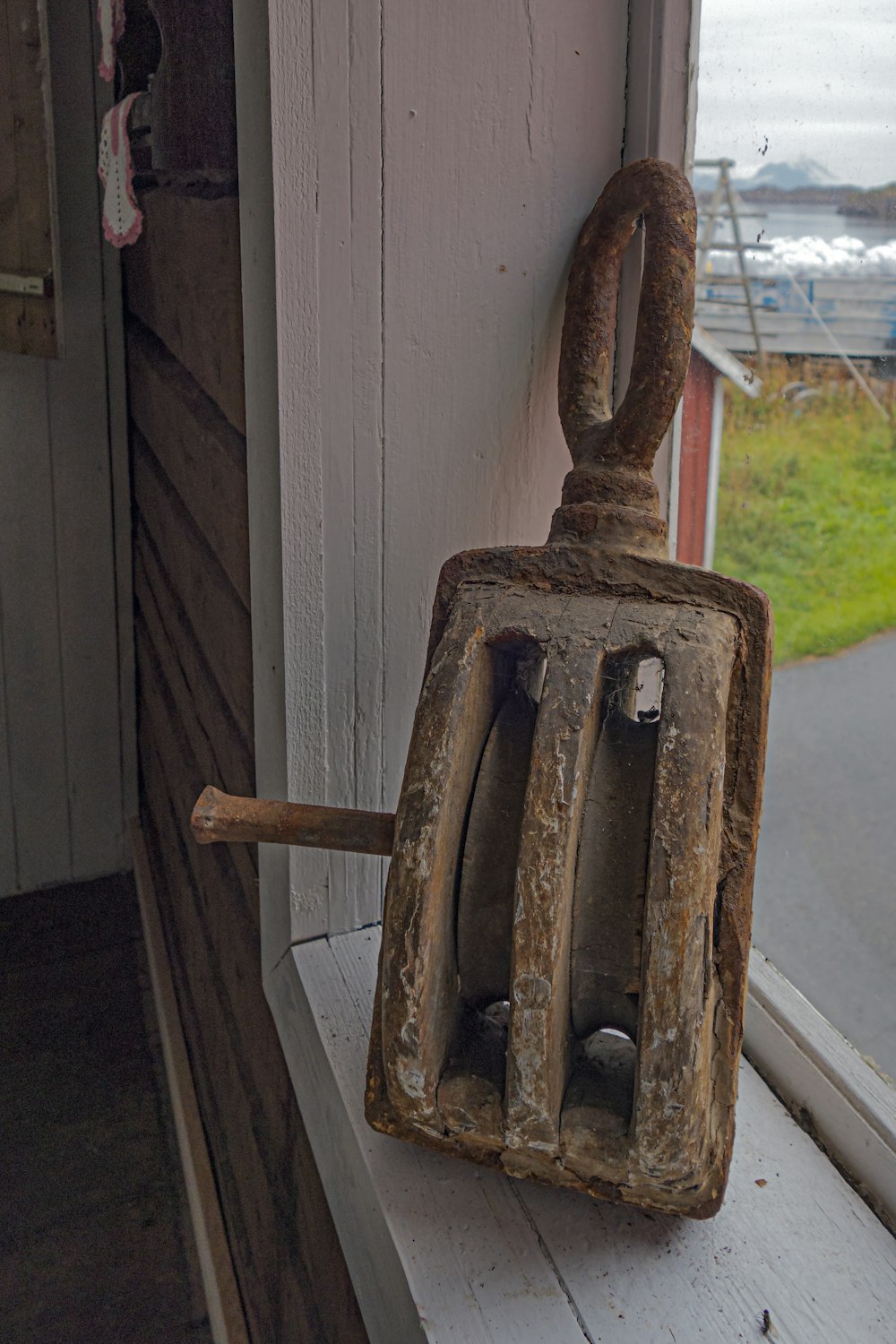 a rusted iron door handle on the side of a house