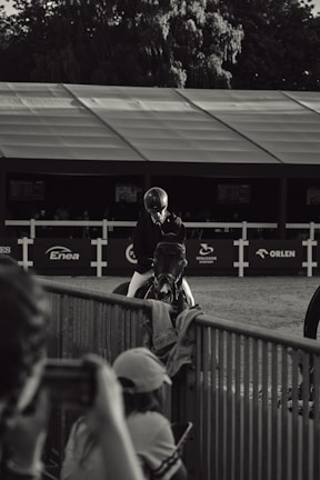 Warm, ambient shot of an equestrian event with noble gallop accessories subtly featured in the crowd.