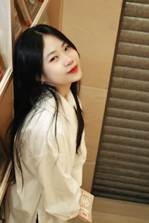 A writer holding a freshly printed book with a smile, standing in a bright room