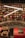 A bookstore filled with a variety of books on wooden shelves arranged in a circular pattern. Bright, white overhead lights create a modern ambiance. Decorative elements such as wrapped gifts are placed on a red, ornately designed ledge.