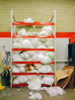 Corner tiered utility wall shelving unit filled with storage bins and garage essentials.