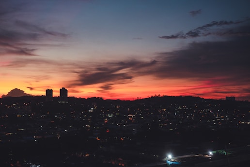 A vibrant African city skyline at sunset with orange hues reflecting the energy of Mbiko TV.