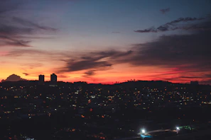 A vibrant sunset behind a city skyline, reflecting the energy of urban life.