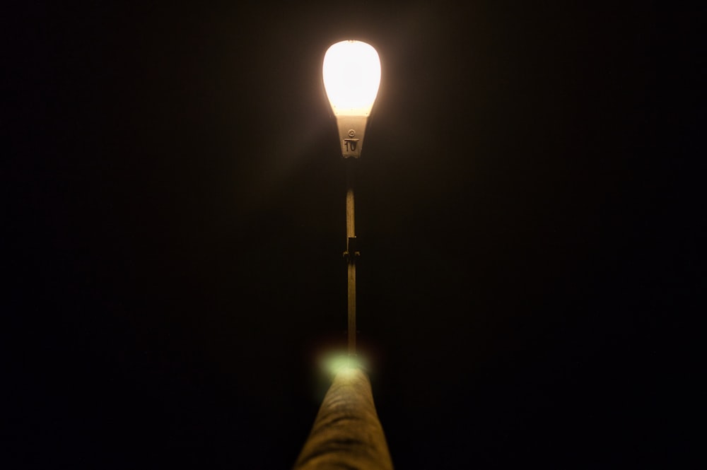 a hand holding a light bulb in the dark