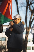 Children playing in front of the Our Lady of Lebanon Church, framed by subtle Lebanese flag colors.