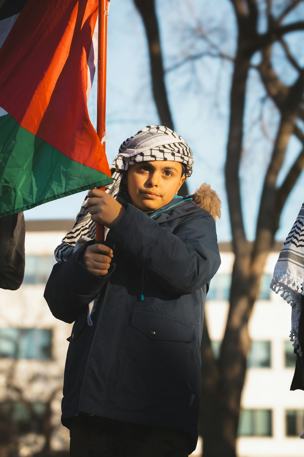 a woman holding a flag in front of a tree