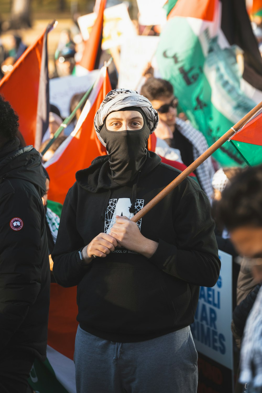 a man wearing a mask and holding a stick