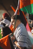 a man holding a multicolored umbrella in a crowd
