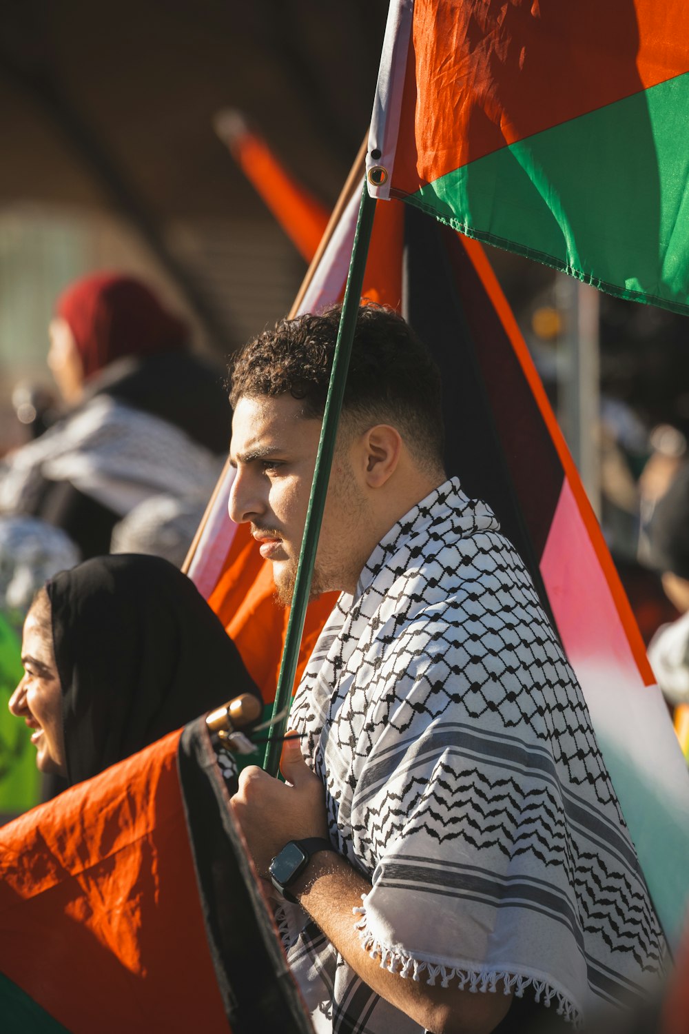 a man holding a multicolored umbrella in a crowd