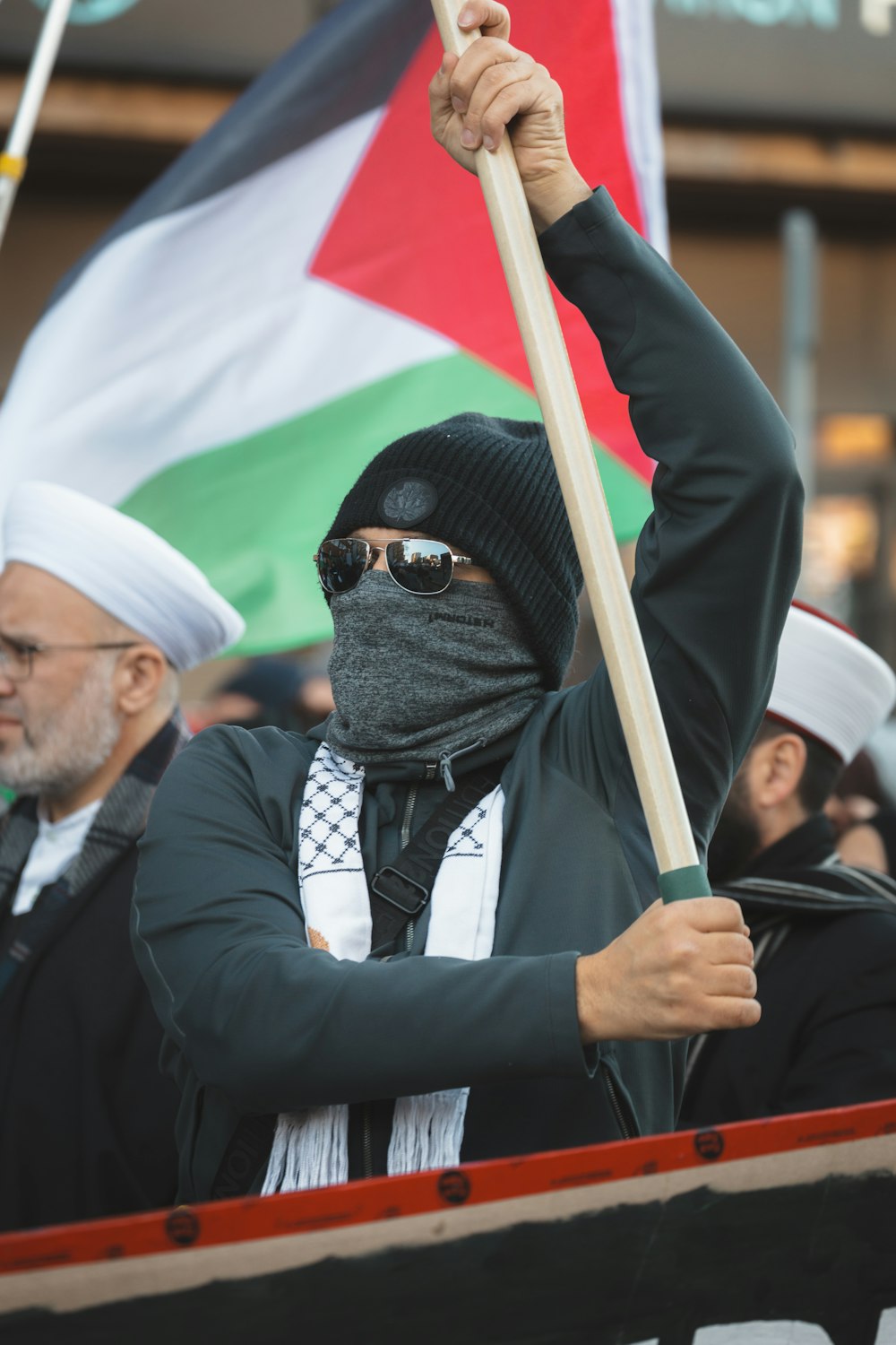 a person in a black mask holding a flag