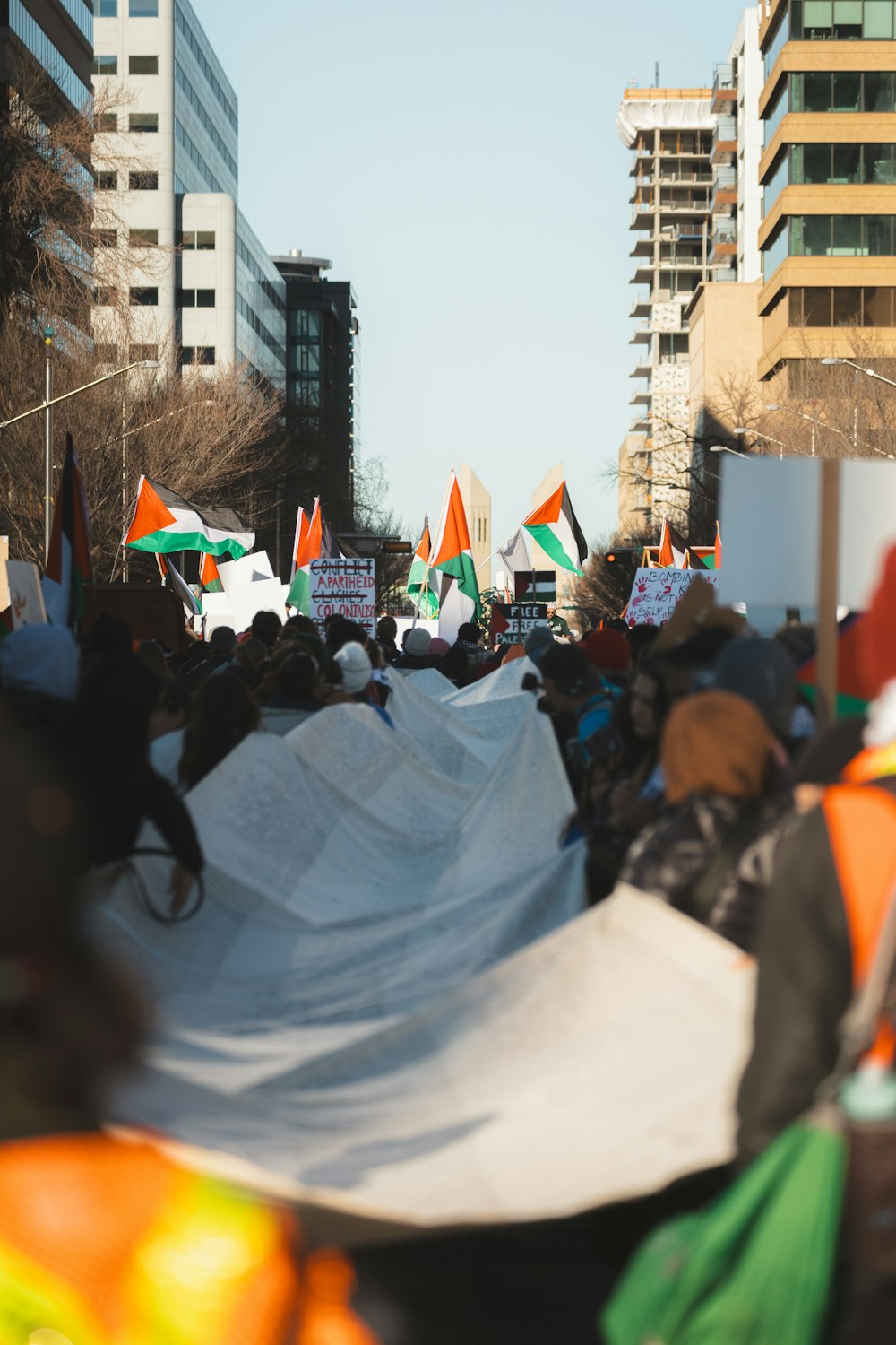 a large group of people holding orange and green flags