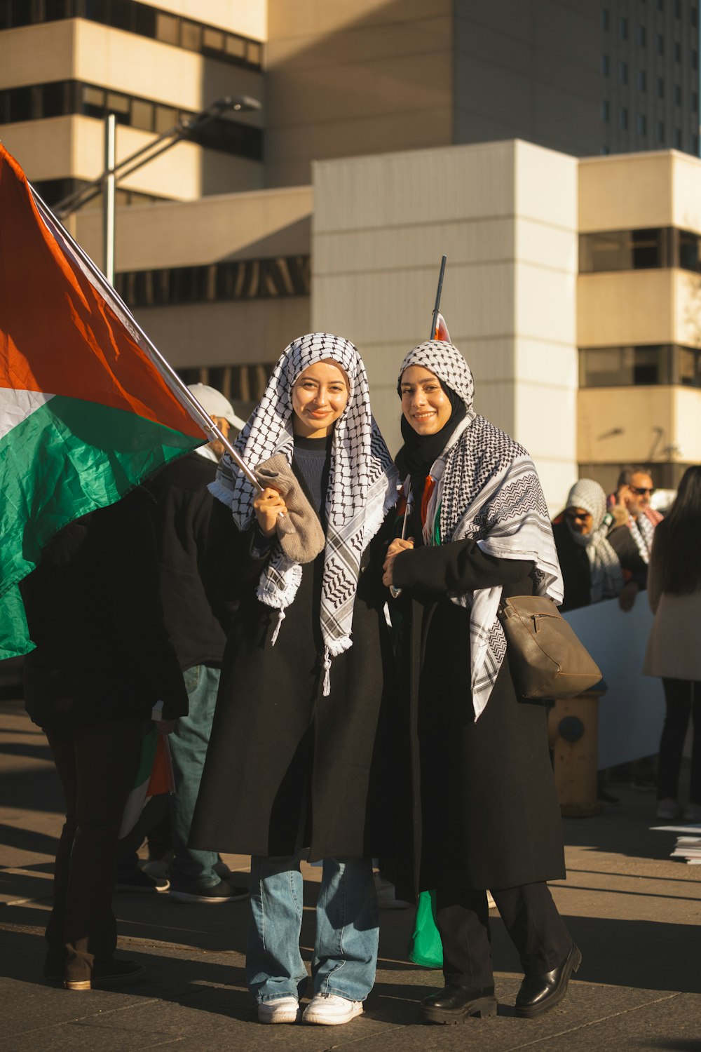 a couple of women standing next to each other holding a flag