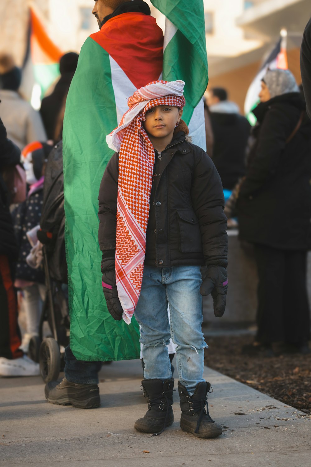 a young boy wearing a scarf and jacket