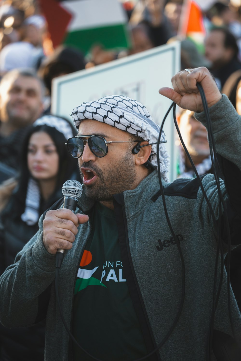 a man holding a microphone in front of a crowd