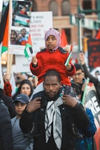a man carrying a child on his shoulders