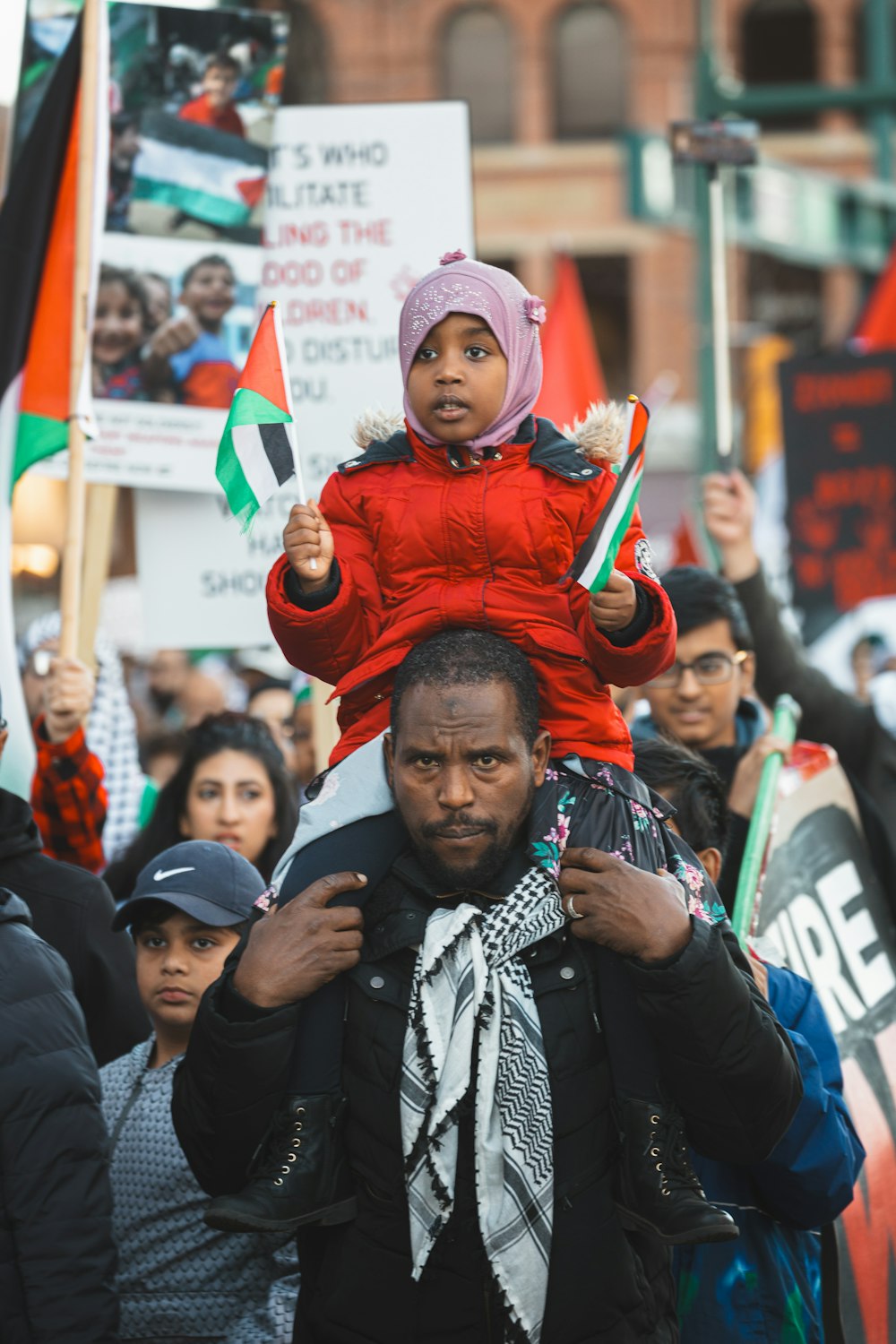 a man carrying a child on his shoulders