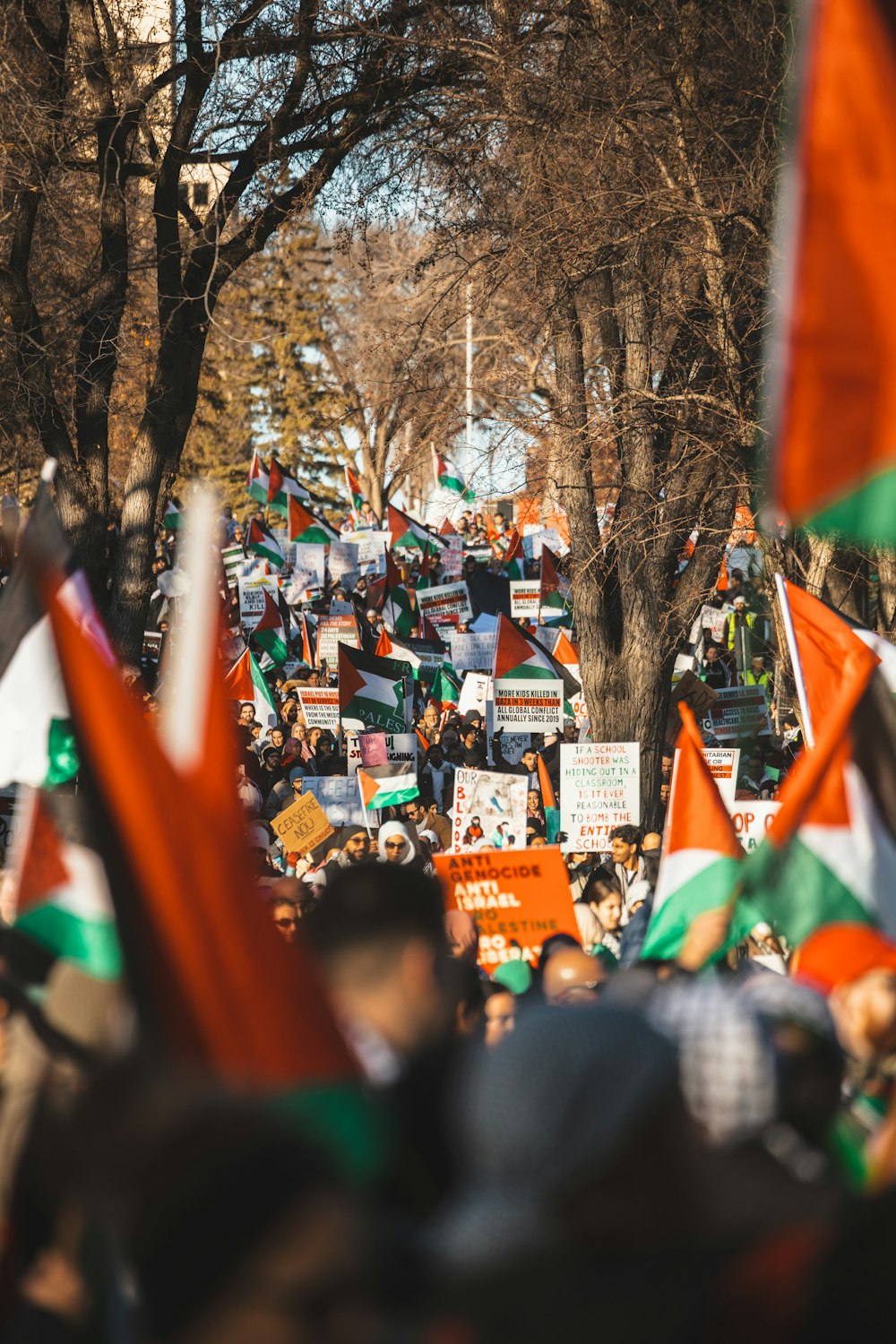 a crowd of people holding orange and green flags