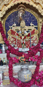 Close-up of intricately carved wooden pooja items arranged neatly on a vibrant cloth.