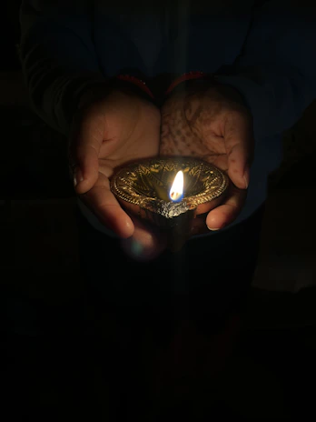 Hands gently holding a glowing light, representing hope and care from the Aashadeep Foundation.
