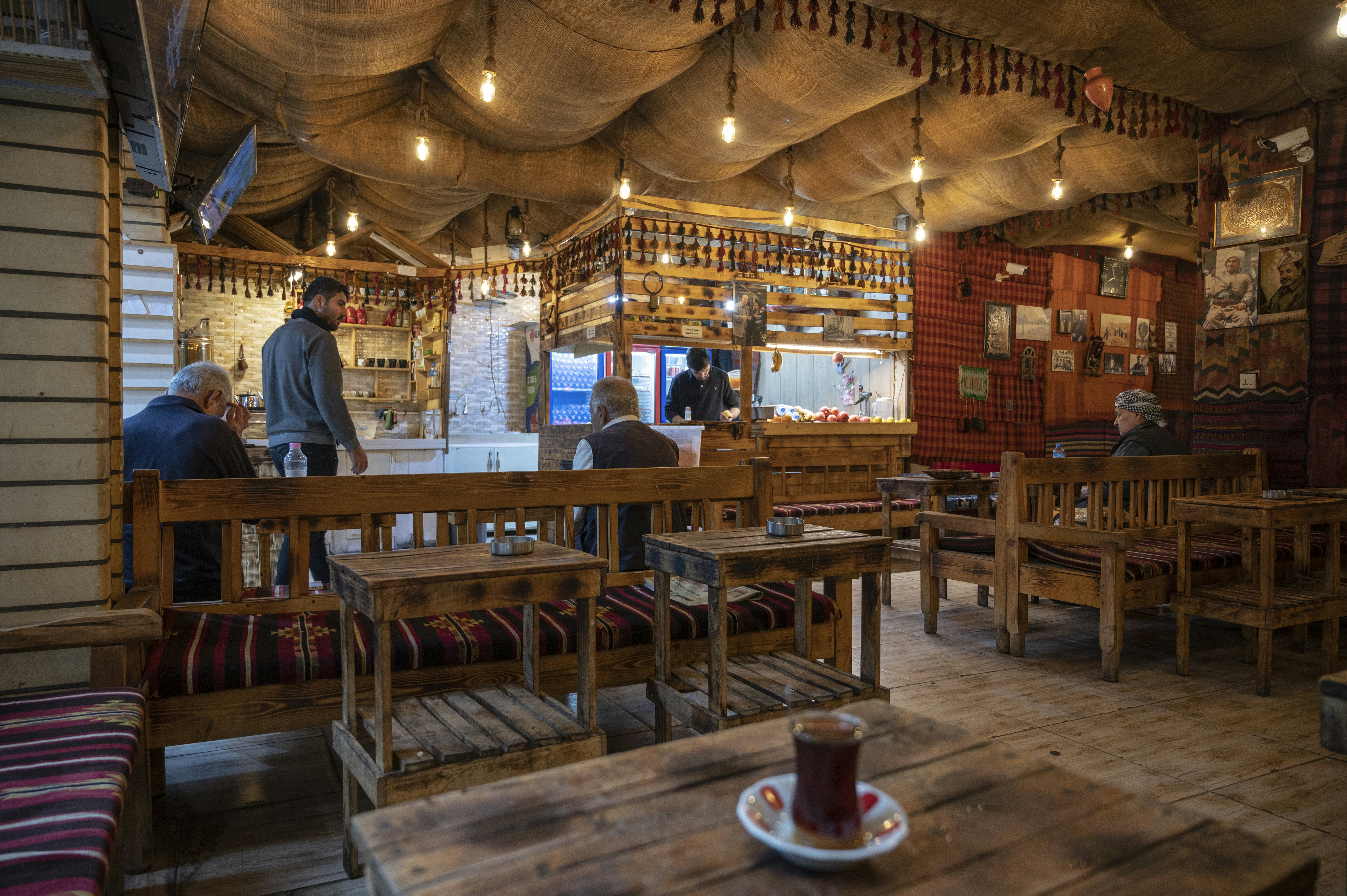 A cozy local café in Oradea with people chatting and enjoying traditional pastries.