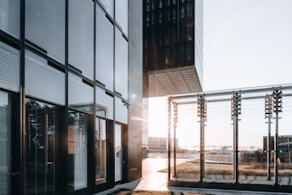 Modern architectural glass panels reflecting a sleek urban skyline at sunset.