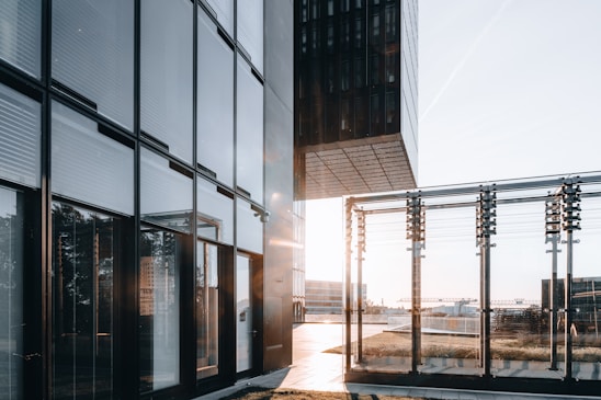 Modern architectural glass panels reflecting a sleek urban skyline at sunset.