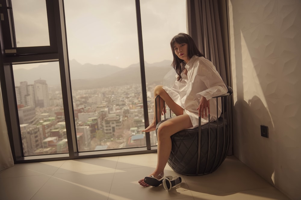 a woman sitting on a chair in front of a window