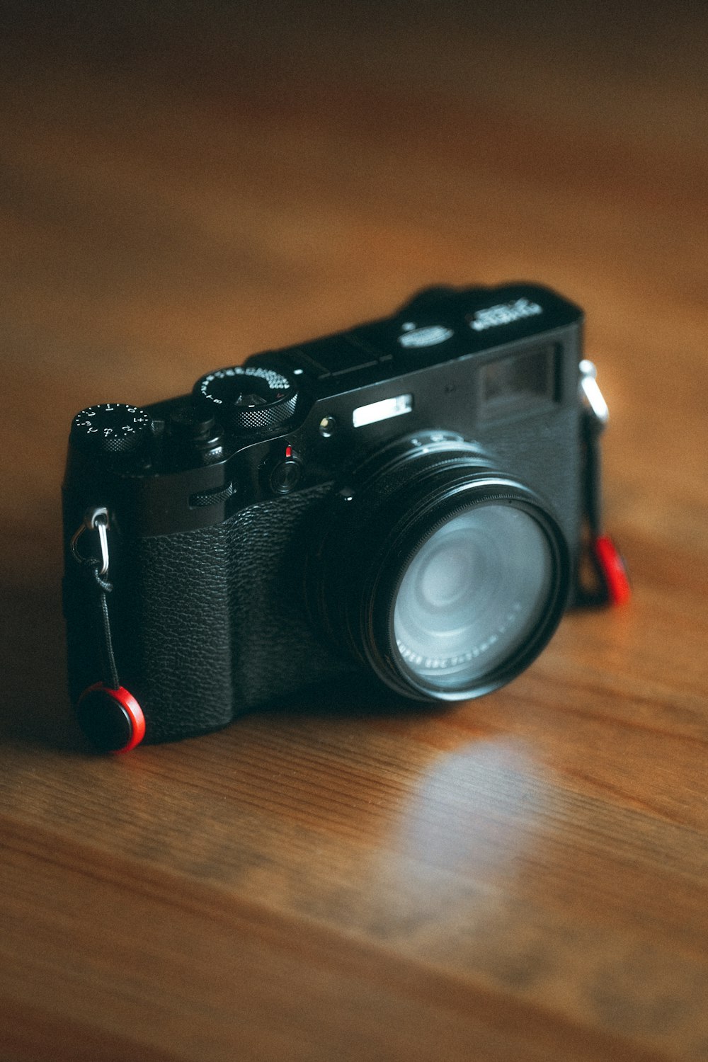 a black camera sitting on top of a wooden table