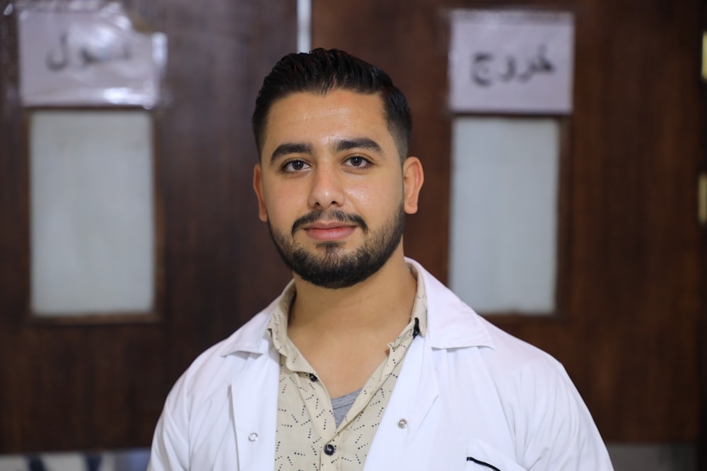 a man in a lab coat standing in front of a door