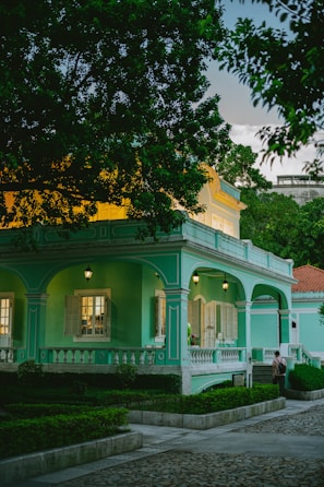 A charming colonial-style home with colorful walls and vibrant flowers outside