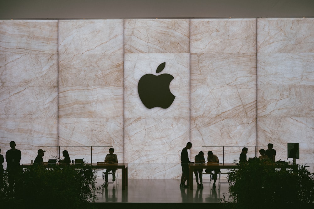 a group of people standing in front of an apple logo