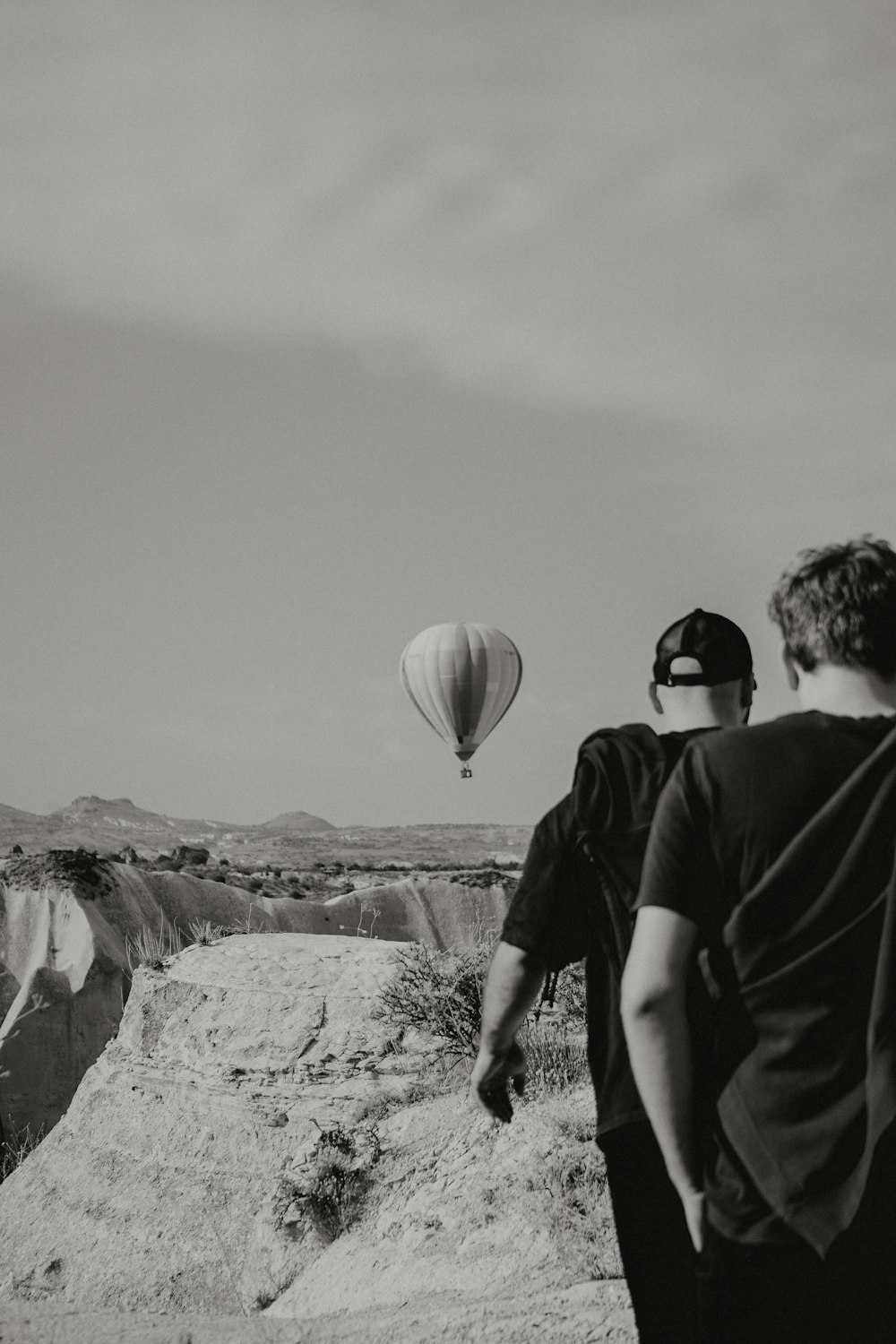 a couple of men standing next to each other near a hot air balloon