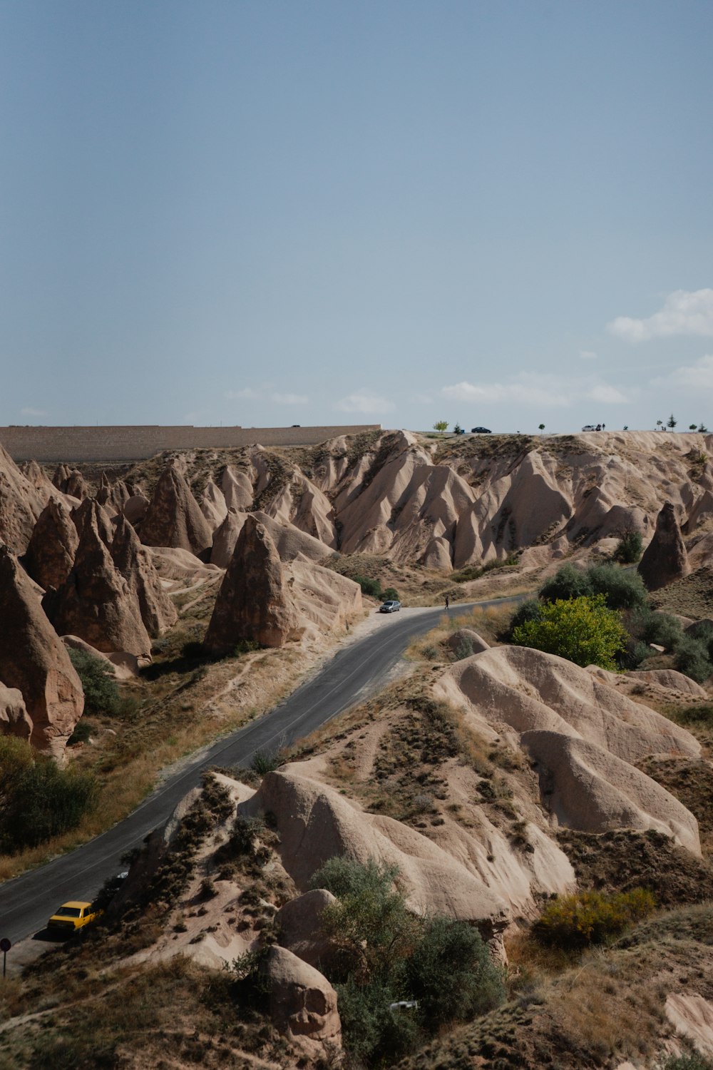 a car driving down a road surrounded by large rocks