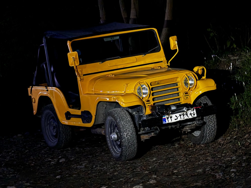 a yellow jeep is parked in the dark