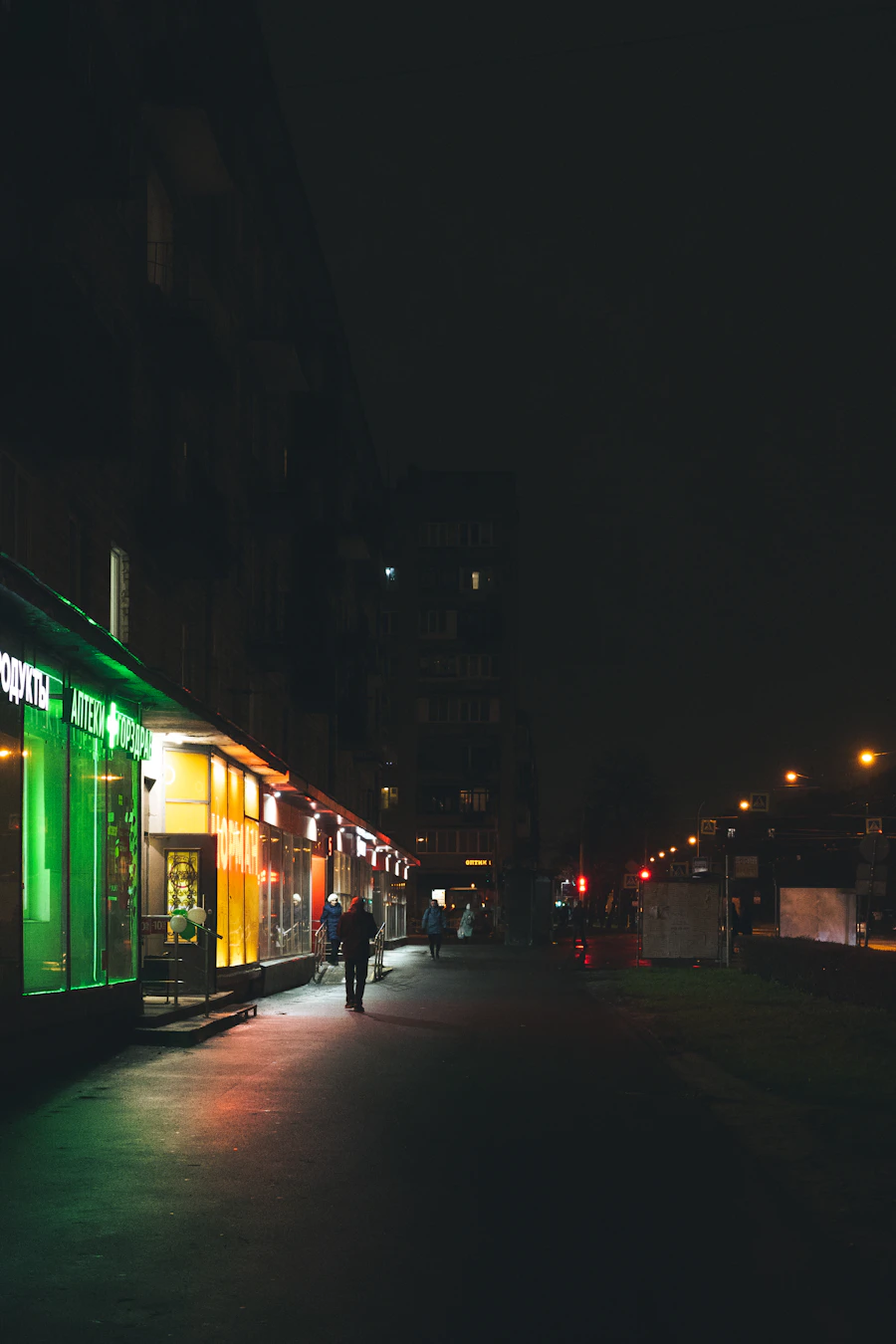 Walking past glowing storefronts at night