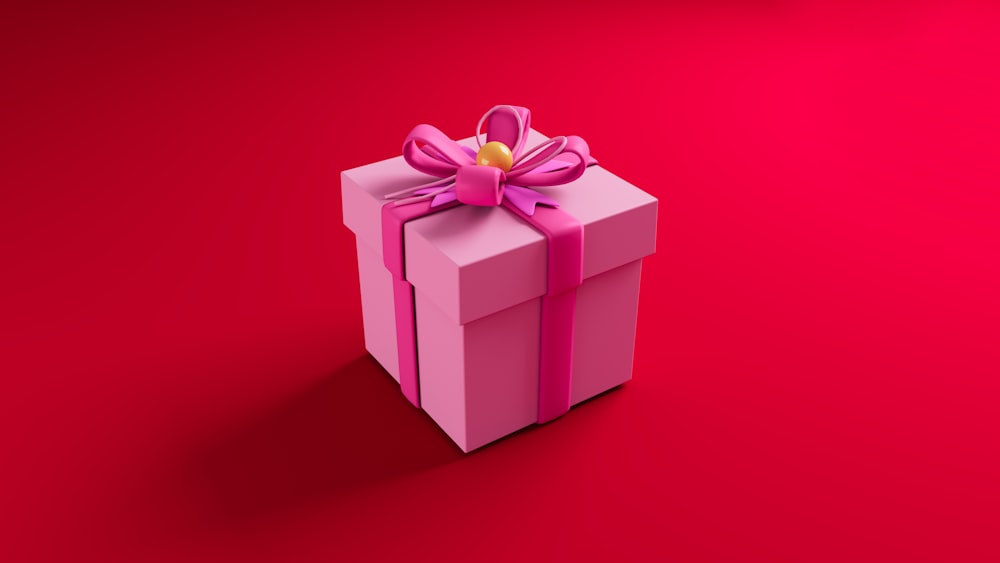 a pink gift box with a bow on a red background