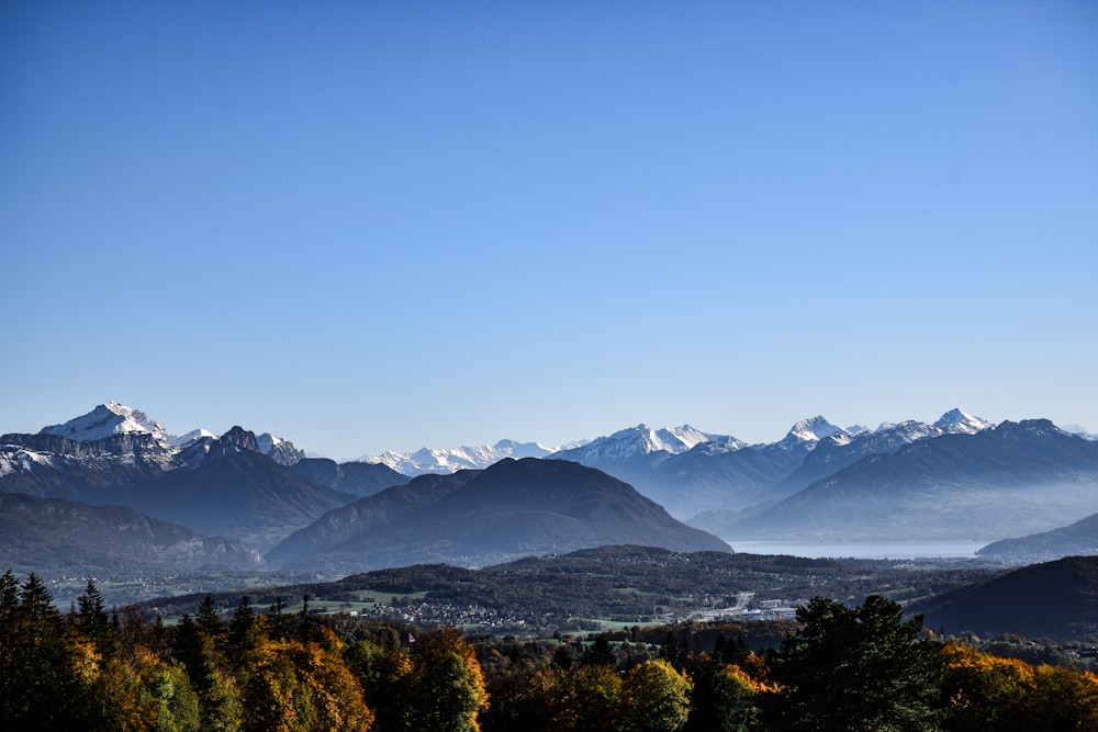 uma vista de uma cordilheira com um lago em primeiro plano