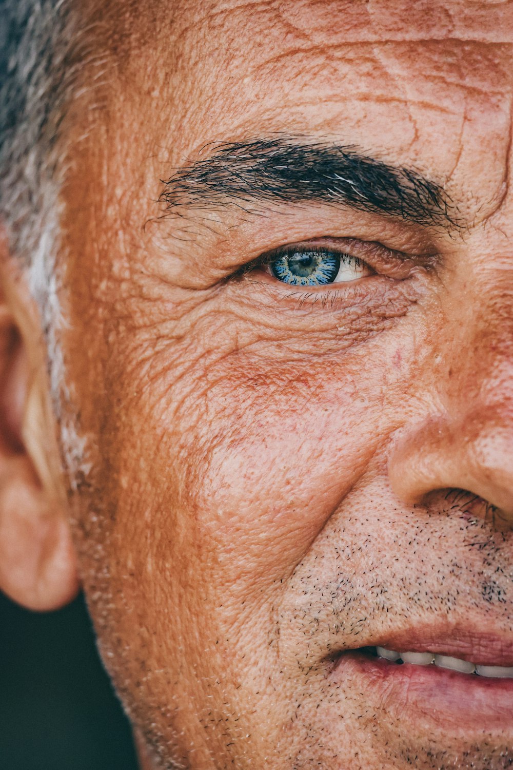 a close up of a man's face with blue eyes