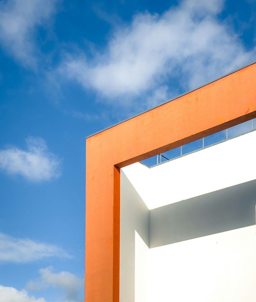 an orange and white building with a blue sky in the background