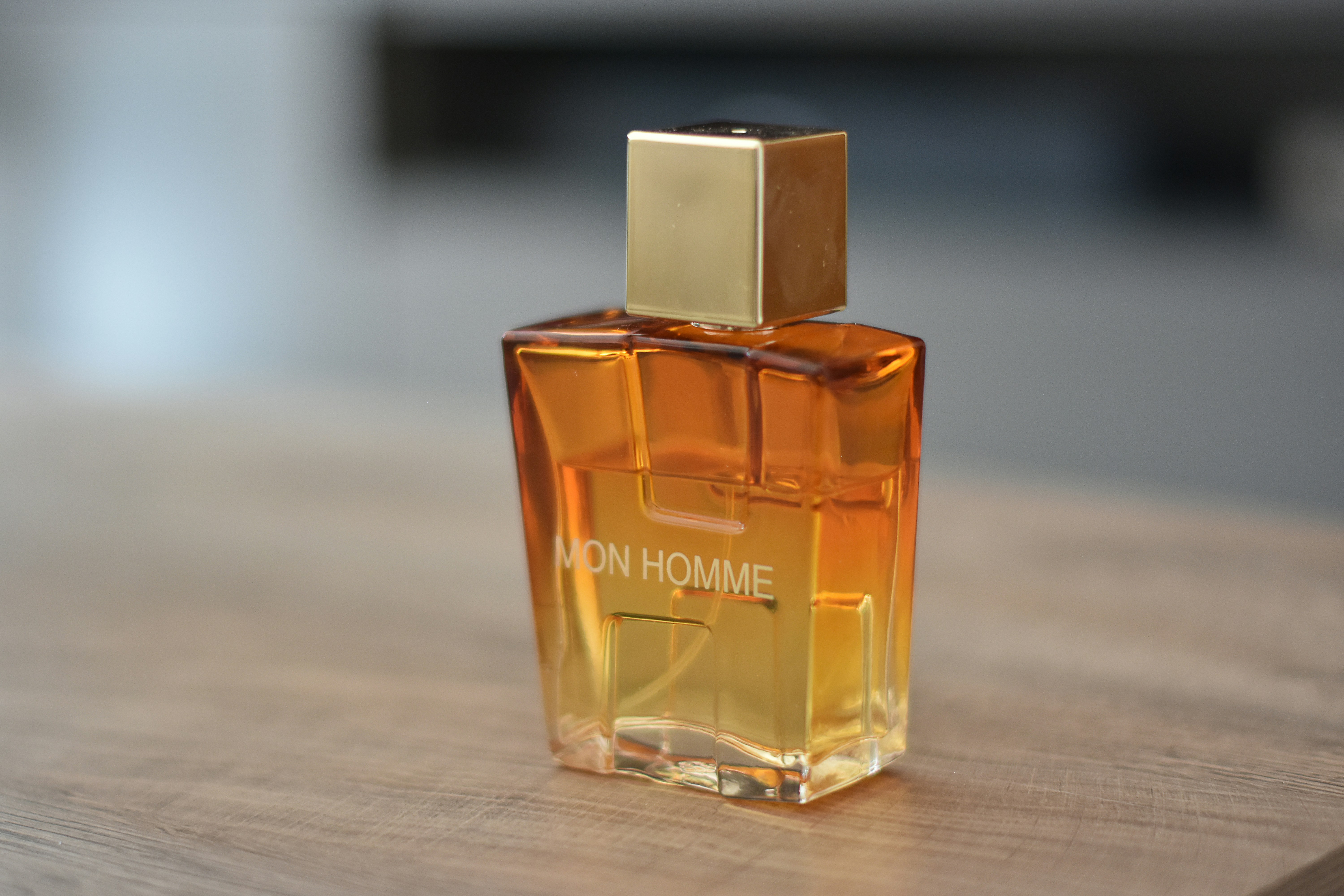Amber glass perfume bottle with gold cap on dark velvet surface
