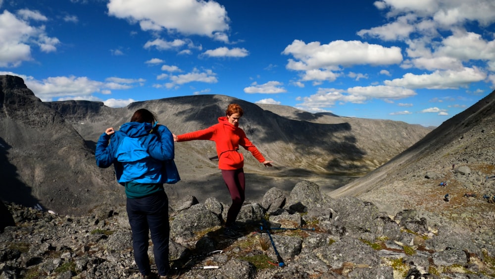 a couple of people standing on top of a mountain