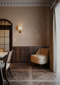 A cozy living room featuring custom wall paneling and elegant lighting fixtures.