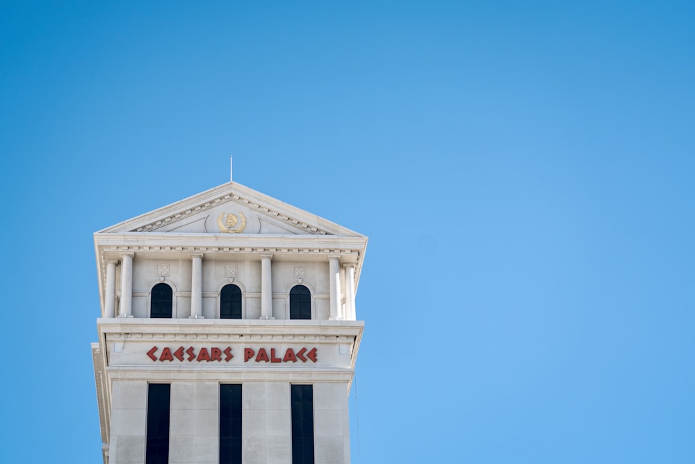 a tall white building with a clock on it's side