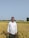 A happy customer standing in a lush field of crops.
