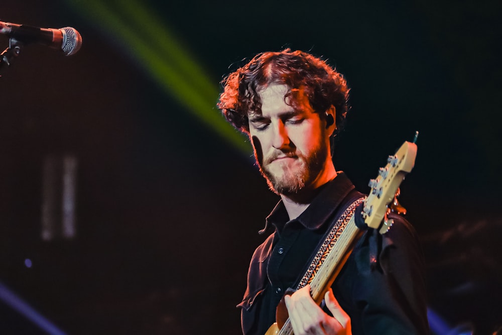 a man playing a guitar on stage at a concert